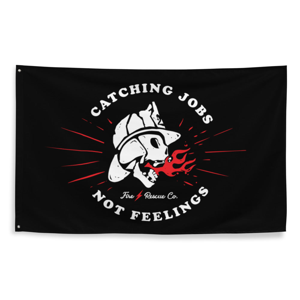 Firefighter Black flag with a white graphic of a skull wearing a fire helmet and text 'Catching Jobs Not Feelings' on a white background.